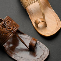 Pair of brown leather sandals with intricate designs on a dark background